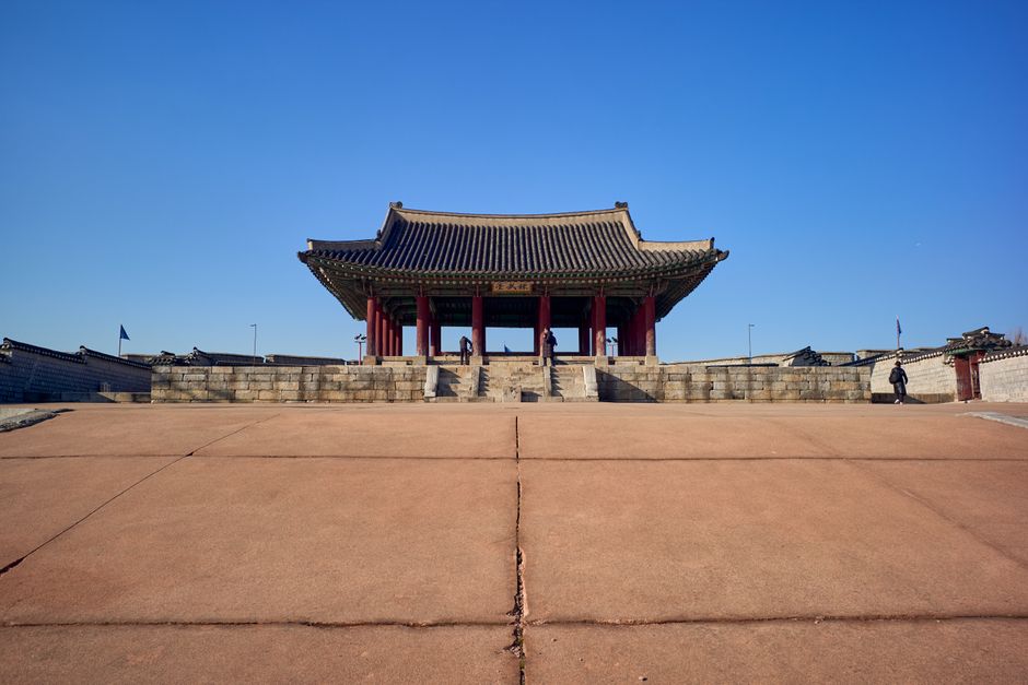 Front view of Gyeongbokgung Palace entrance with clear blue sky, showcasing traditional Korean architecture.