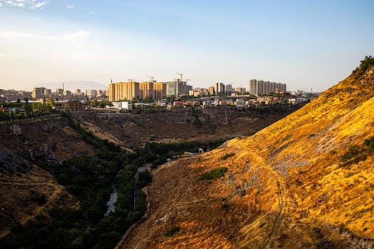 Panoramic view of Yerevan skyline during golden hour, highlighting urban expansion and natural landscape.