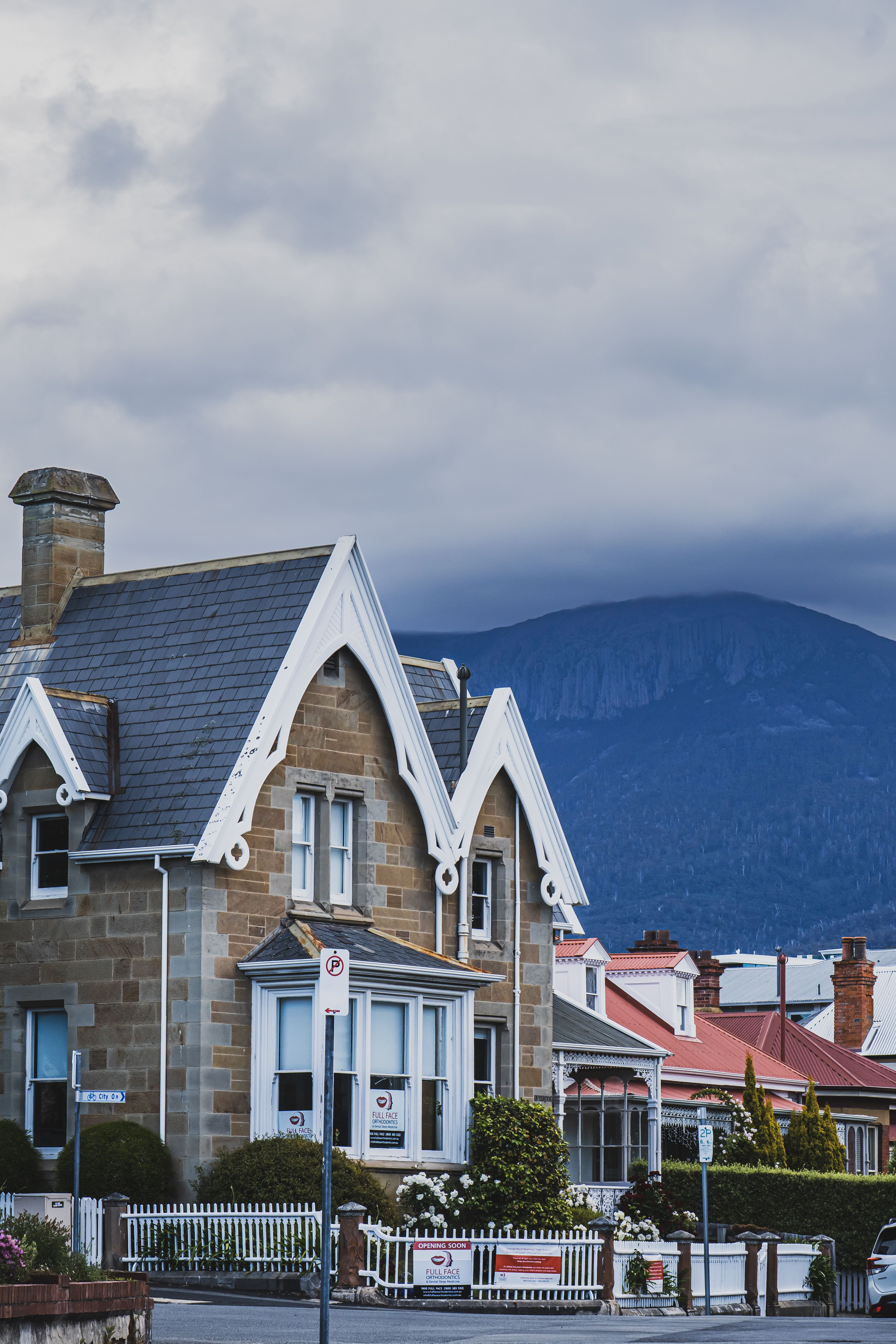 Quaint Victorian-style house set against a majestic mountain backdrop, ideal for architecture and scenery enthusiasts.