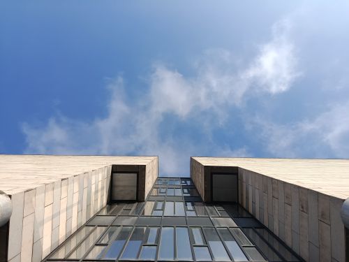 Free A contemporary building shot from below against a clear blue sky on a sunny day. Stock Photo