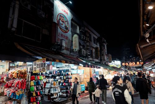 Free Lively Taipei night market scene with people shopping under vibrant lights. Stock Photo