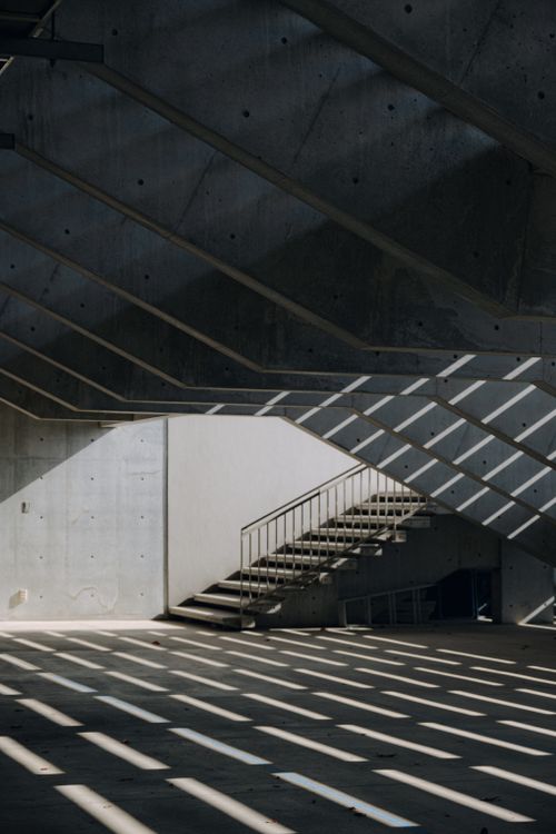Free A striking architectural image of a concrete staircase with dramatic shadows indoors. Stock Photo