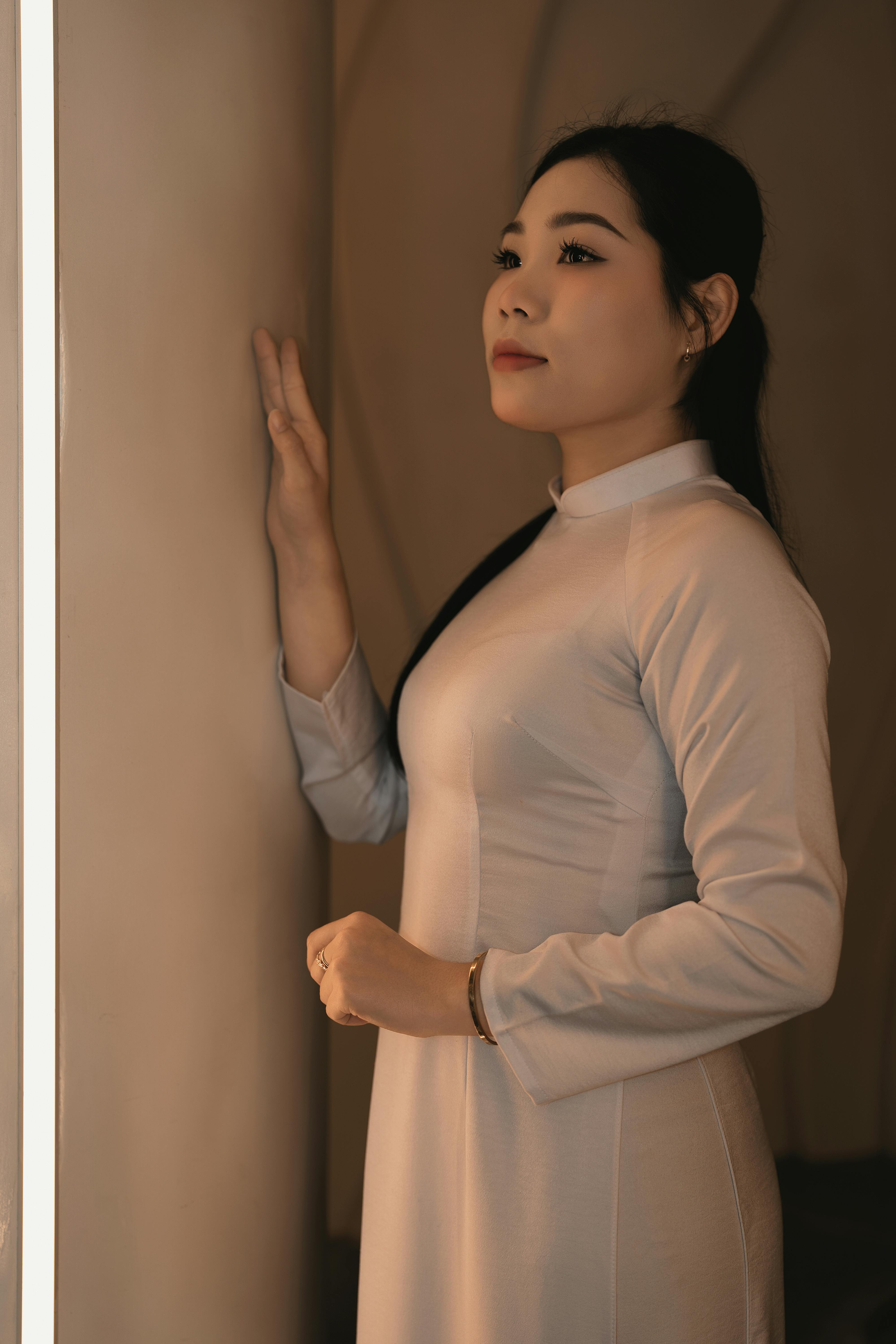 무료 전통 의상을 입은 우아한 여인이 실내에서 사색에 잠긴 듯 바라보는 모습의 초상화. 스톡 사진