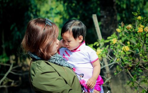 Free A touching moment between a mother and child in a lush garden setting in Vietnam. Stock Photo