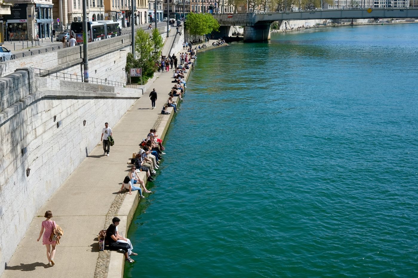 Promeneurs sur les quais du Rhône à Lyon par une journée ensoleillée