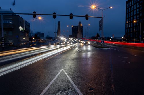 Free A bustling city intersection at night with striking light trails from moving vehicles lighting up the scene. Stock Photo