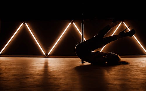 A woman doing a handstand in front of neon lights