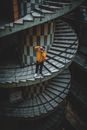 Man in Yellow Jacket and Black Pants Standing on Stairs