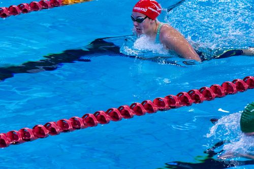 Free Swimmer in competitive race at indoor swimming pool with clear blue water. Stock Photo