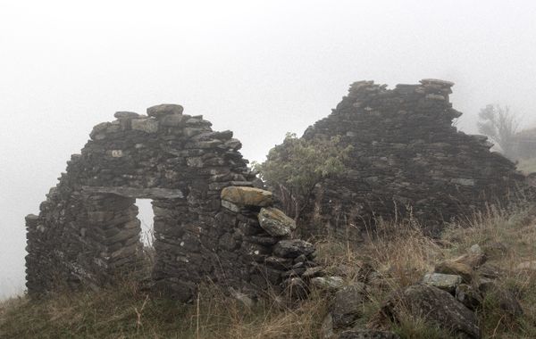 Stone ruins standing in heavy fog. Photo by Marek Piwnicki on Pexels