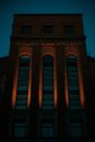 一座高大的砖砌建筑，在夜间照明下，拱形窗户展现了建筑的优雅