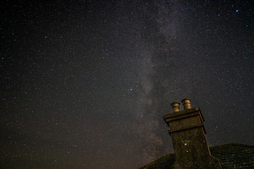 Free Silhouette of a chimney against a bright starry night sky showcasing the Milky Way. Stock Photo