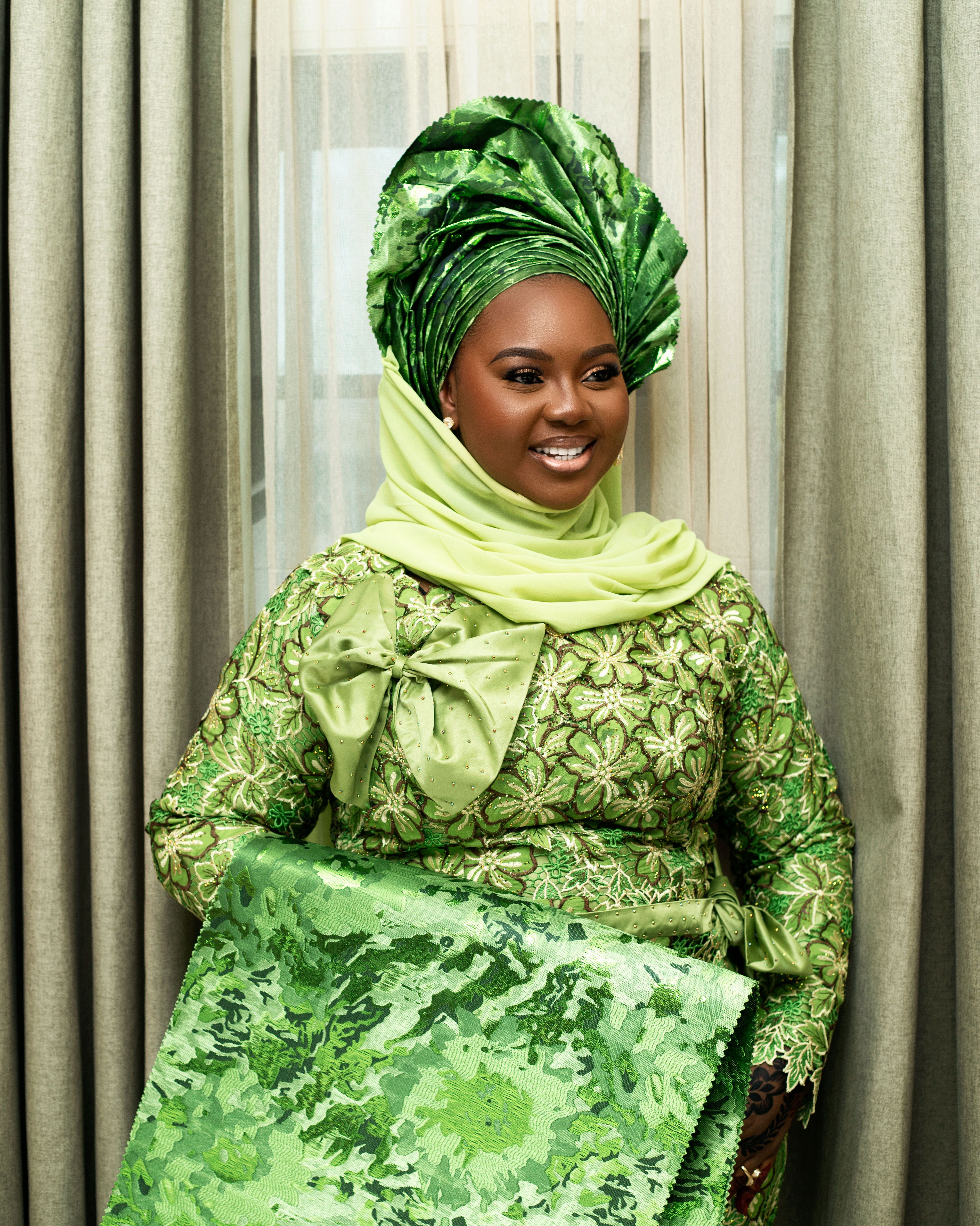 Smiling Woman in Traditional Green African Attire · Free Stock Photo