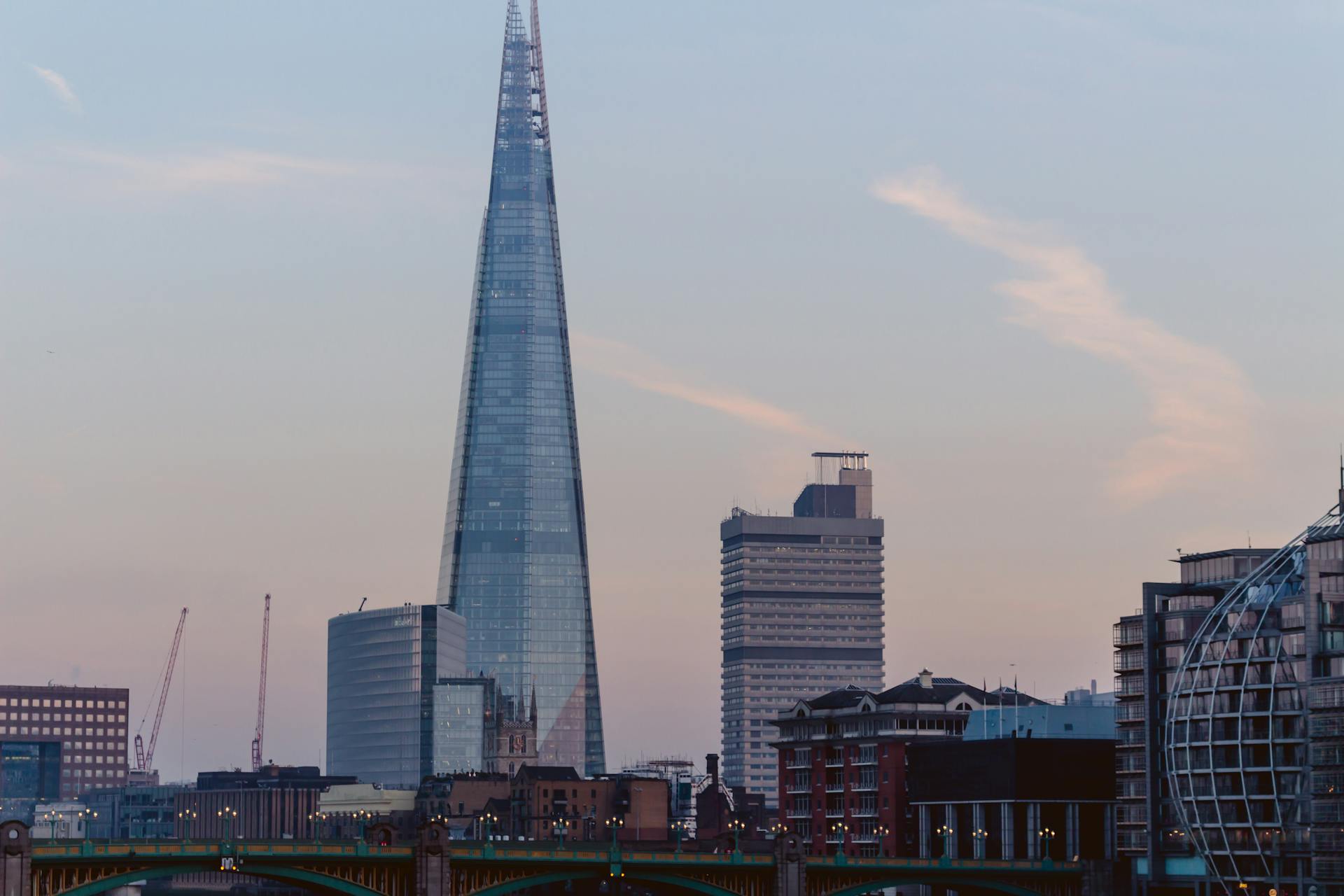 A view of The Shard and surrounding buildings in London at dusk, highlighting modern architecture.