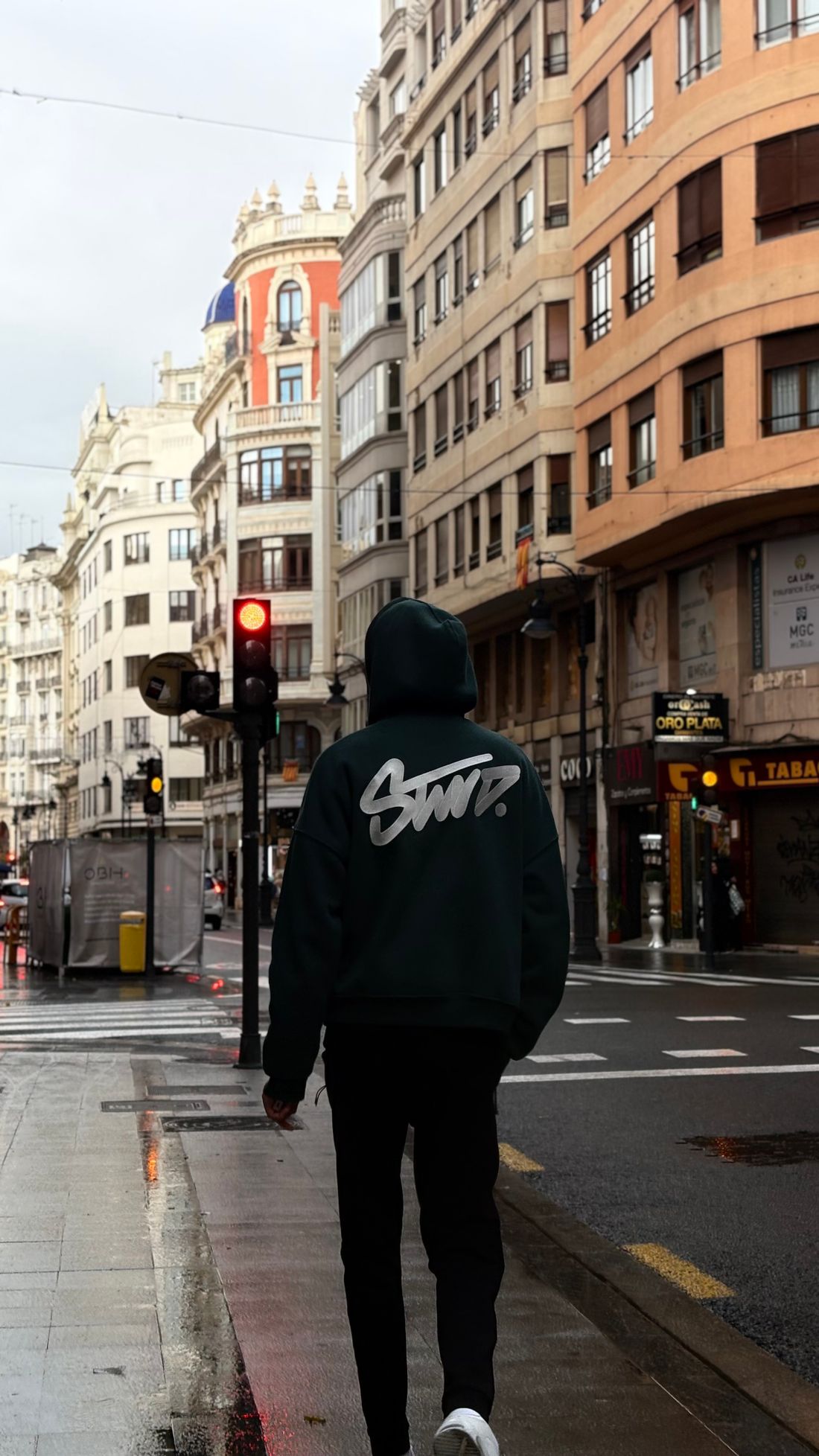 Persona con sudadera caminando por una calle en España