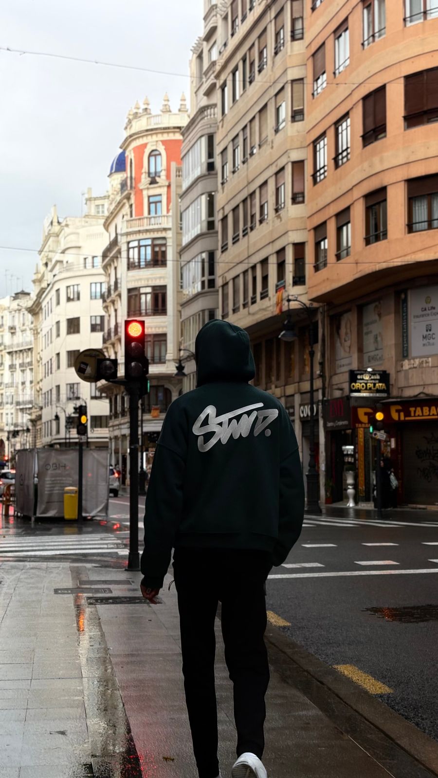 Persona con hoodie en una calle urbana de España