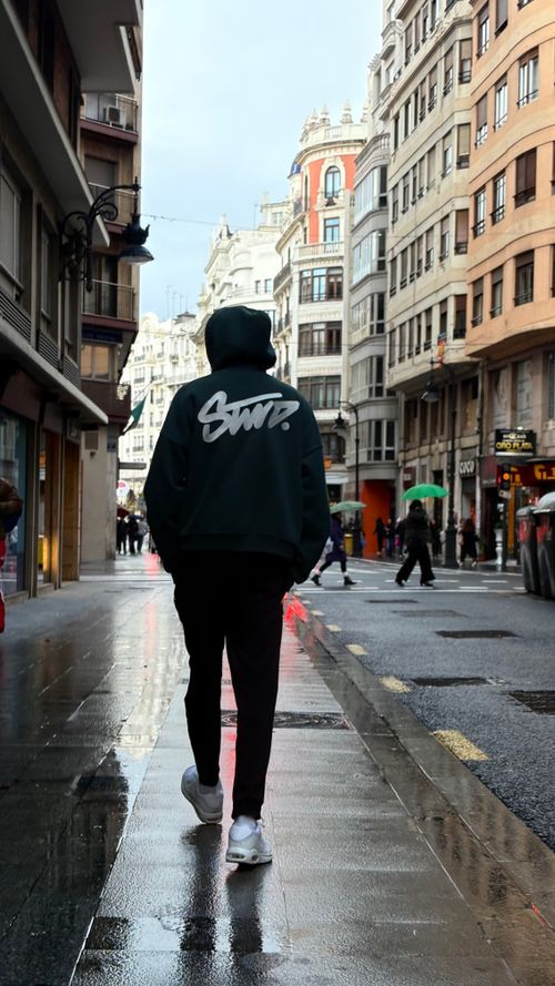 Free Person walks down a wet city street surrounded by European architecture. Stock Photo