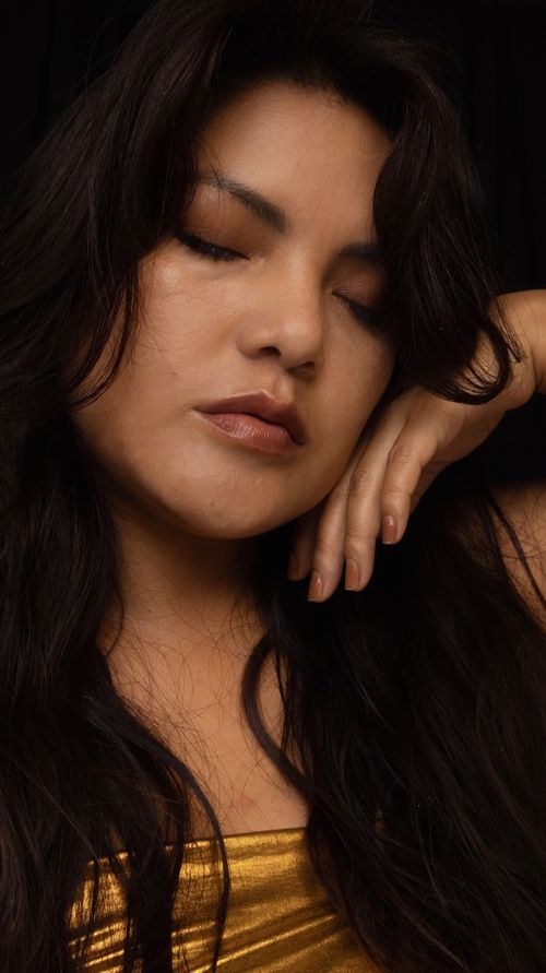 Free Elegant close-up portrait of a woman in Cusco, with a serene expression and long dark hair. Stock Photo