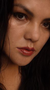 Detailed close-up portrait of a woman with dark hair and makeup.