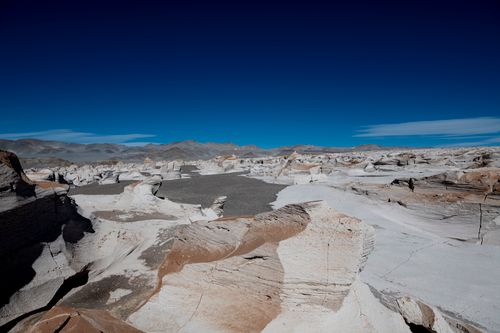 Free Explore stunning white rock formations set against a vivid blue sky, showcasing nature's raw beauty in a remote desert landscape. Stock Photo