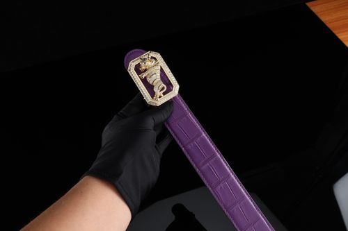 Free Elegant purple leather belt with gold tiger buckle. Perfect for luxury fashion and gifting. Stock Photo