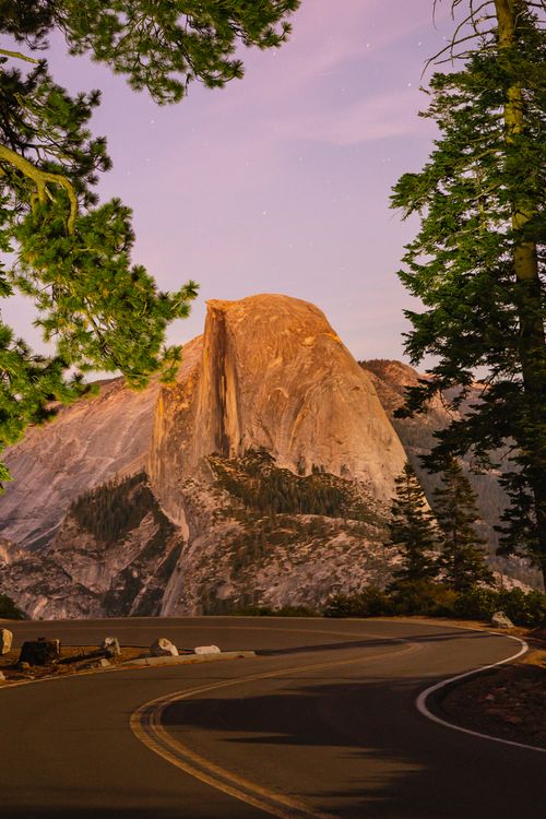 Free Captivating sunset scene of Half Dome with a winding road in Yosemite National Park. Stock Photo