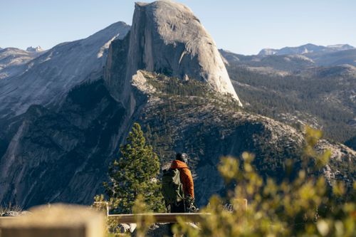 Free A hiker admires the iconic Half Dome at Yosemite National Park during a clear fall day. Stock Photo