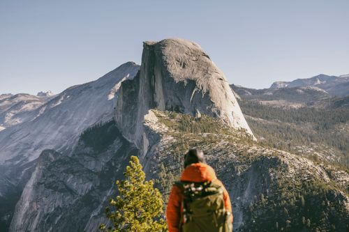 Free Hiker admires the majestic view of Half Dome in Yosemite National Park during fall. Stock Photo