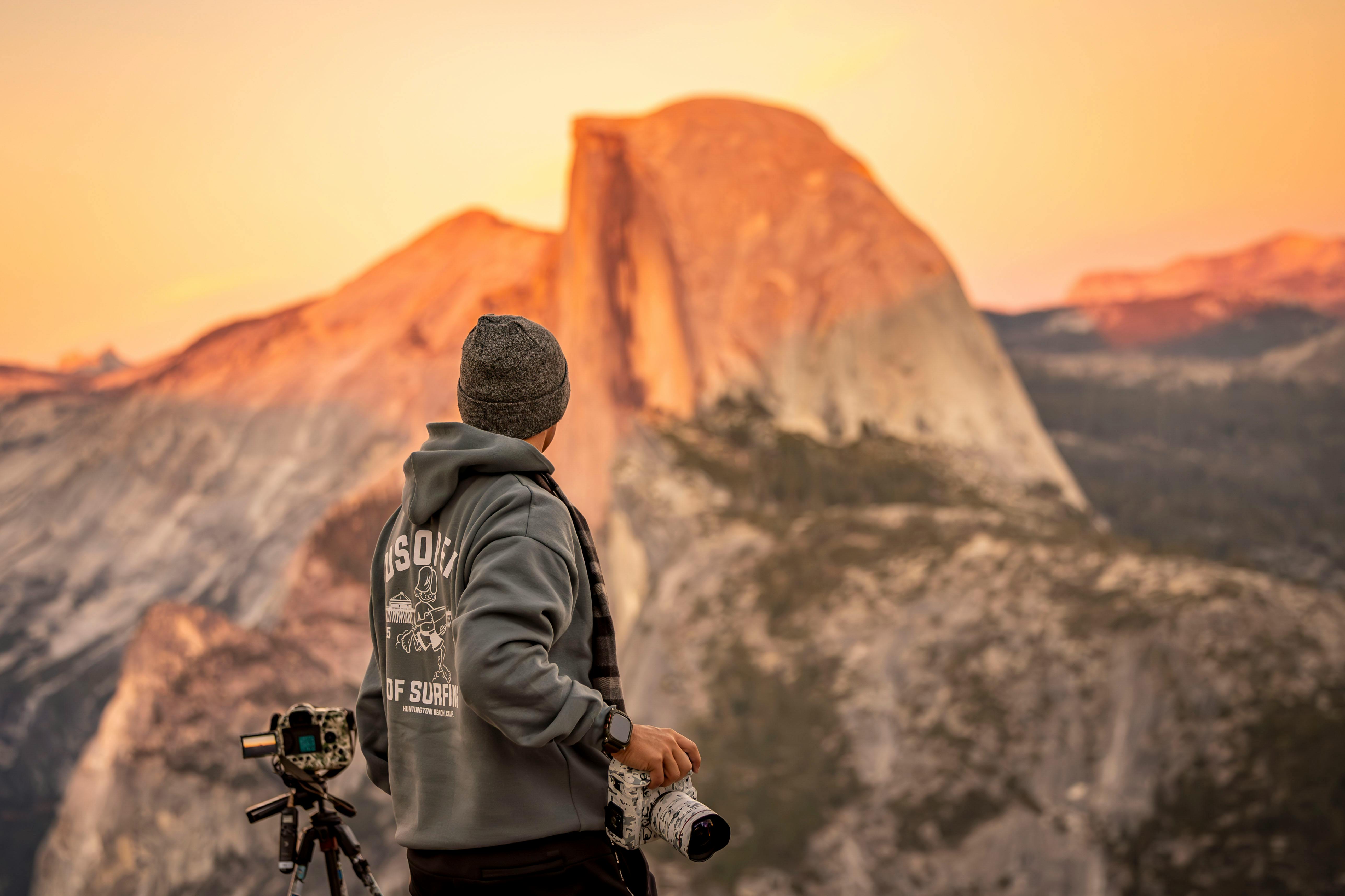 A photographer captures the stunning beauty of Half Dome in Yosemite during a serene fall sunset.