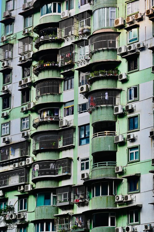 Free Colorful apartment building facade with balconies and air conditioning units. Stock Photo