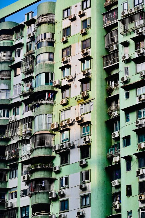 Free Close-up of a green apartment building facade with balconies and air conditioners. Stock Photo