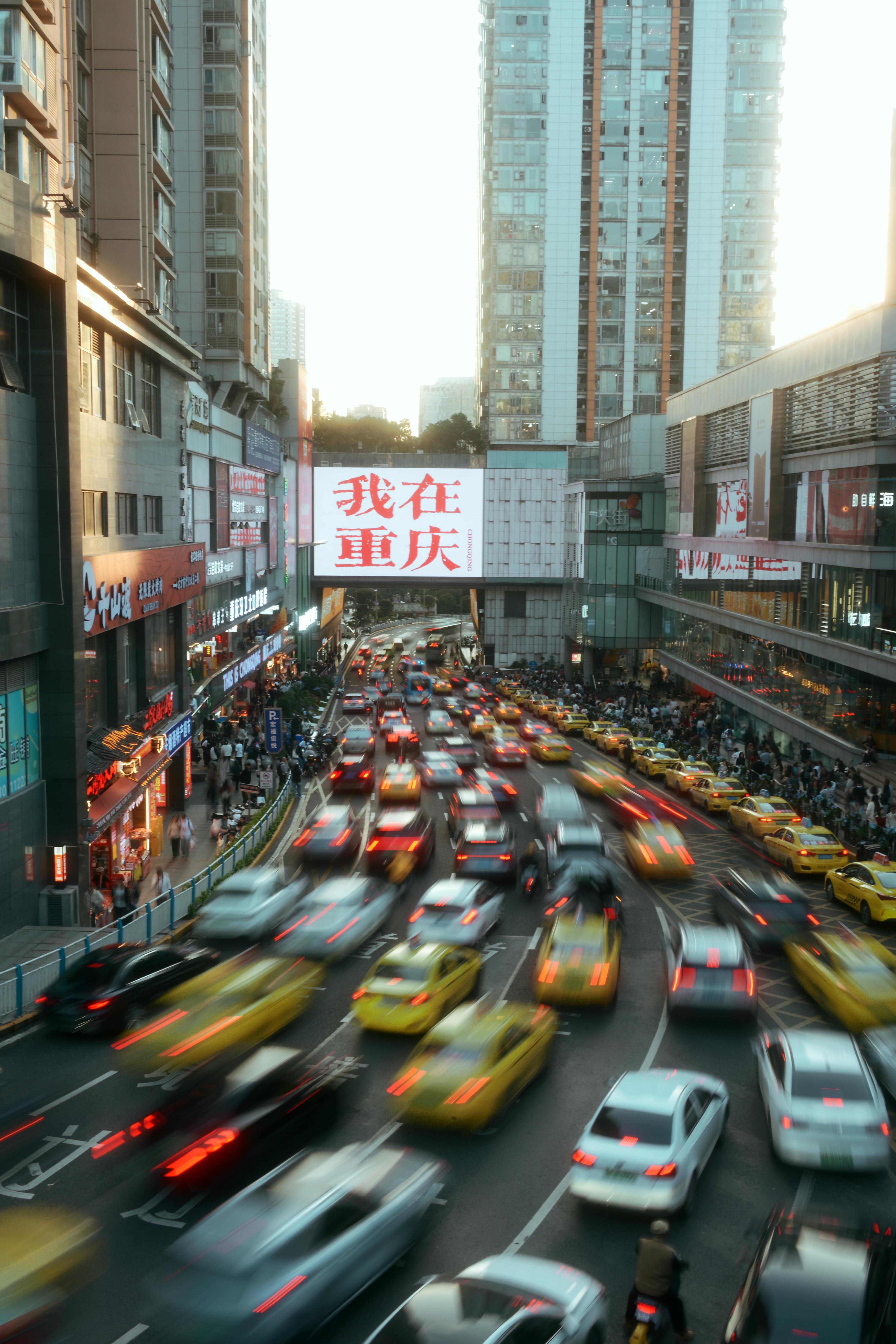 High angle view of a busy city street scene in Chongqing, China during dusk with vibrant traffic motion.