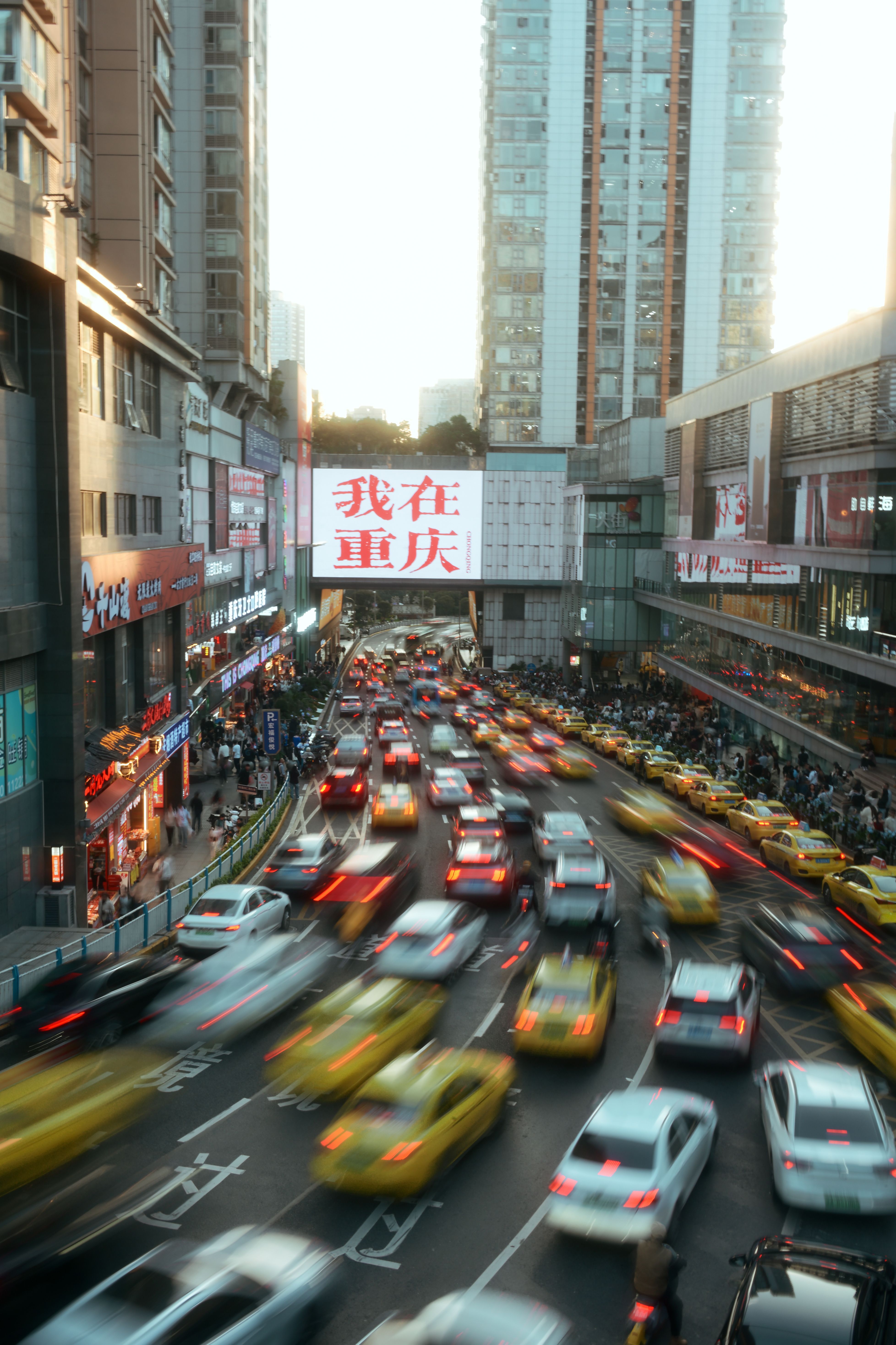 High-angle view of a bustling street in Chongqing, China, with heavy traffic at twilight.