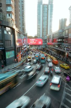A dynamic city street scene with bustling traffic and towering buildings during the day.