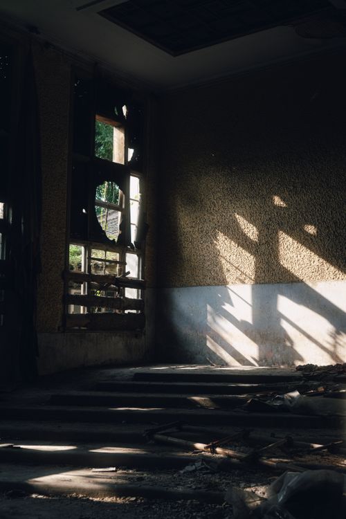 Free Moody photo of an abandoned building interior with dramatic sunlight casting shadows. Stock Photo