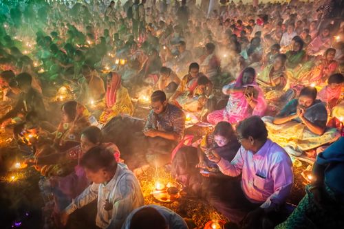 Free Captivating scene of a traditional festival in Kolkata, India with people gathered and lighting lamps. Stock Photo