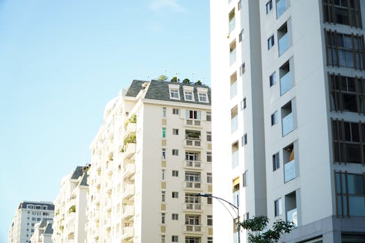 Bright day view of white urban residential apartment buildings.