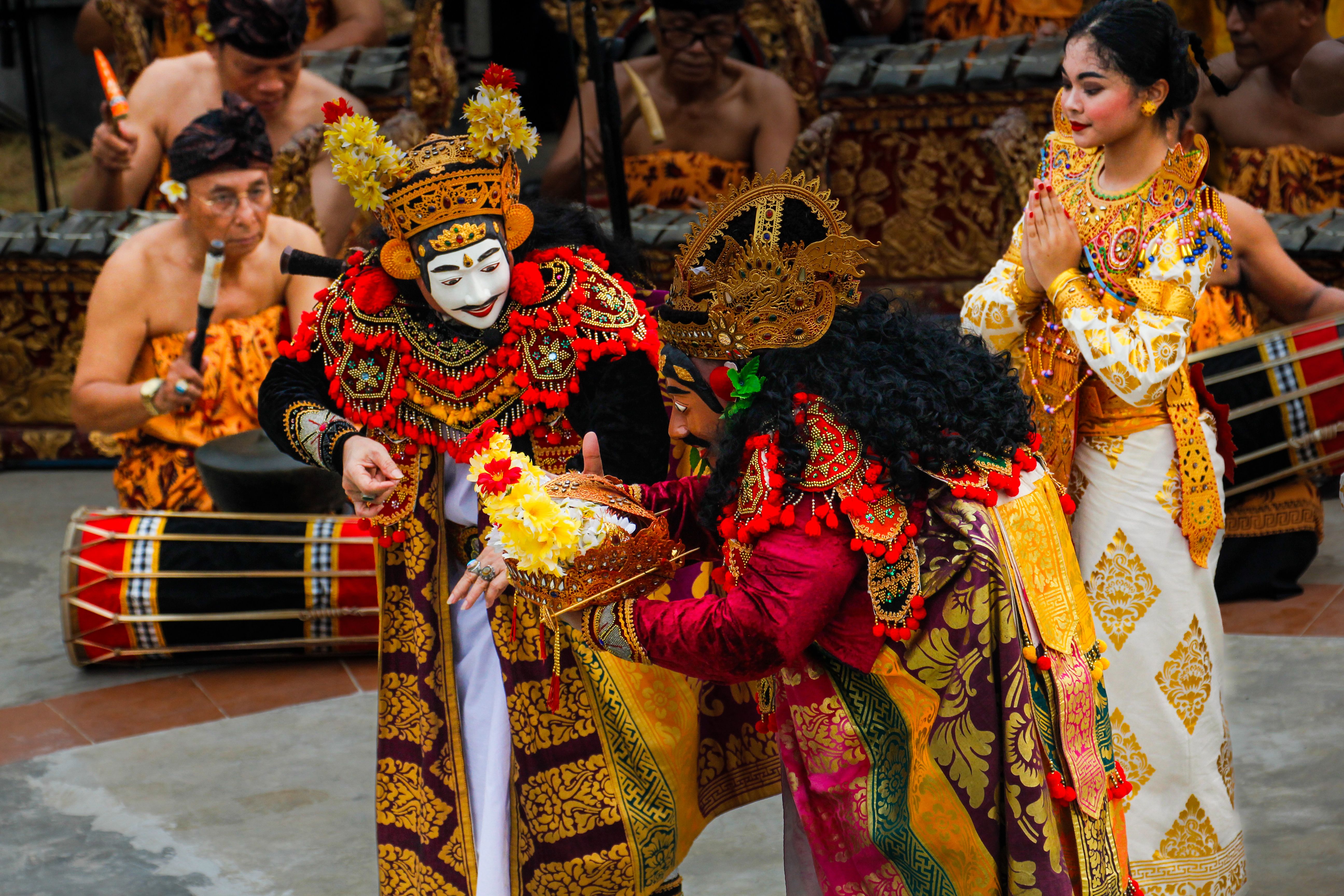 Vibrant Balinese dance with intricate costumes during a cultural ceremony outdoors.