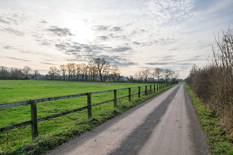 Golden sunrise over rural farmland with fence