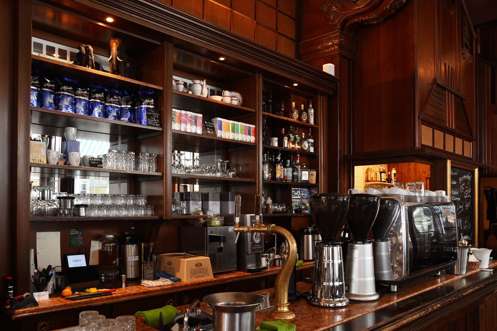 A warmly lit coffee counter with ceramic cups and an espresso machine