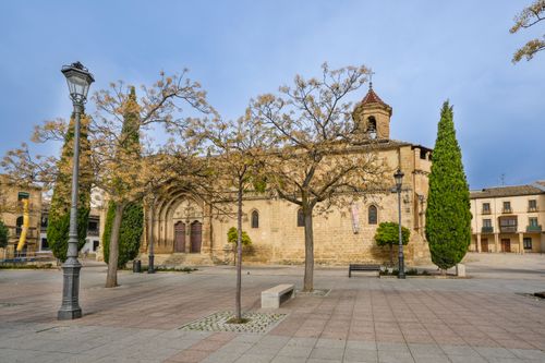 Free View of a historic church and plaza in Úbeda, Andalucía, with trees and picturesque architecture. Stock Photo