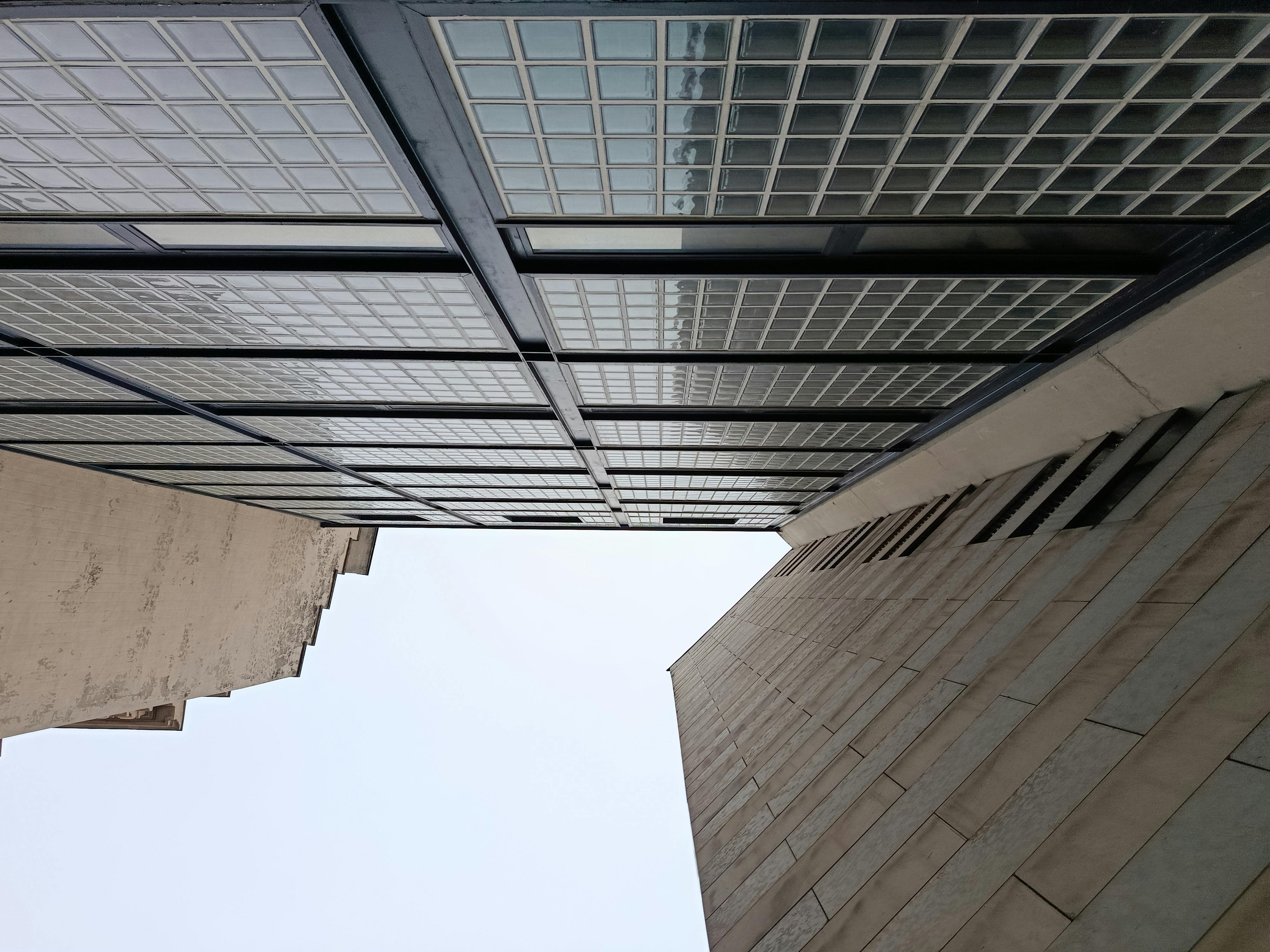 Kostnadsfria Uppåtsikt över moderna byggnader med glasfasader och klar himmel. Stock foto