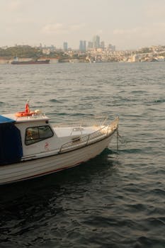 Peaceful capture of a boat on Bosphorus with İstanbul skyline in the background.
