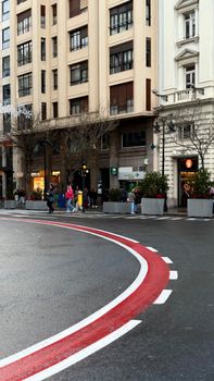 City street scene with people walking in front of classic European architecture.