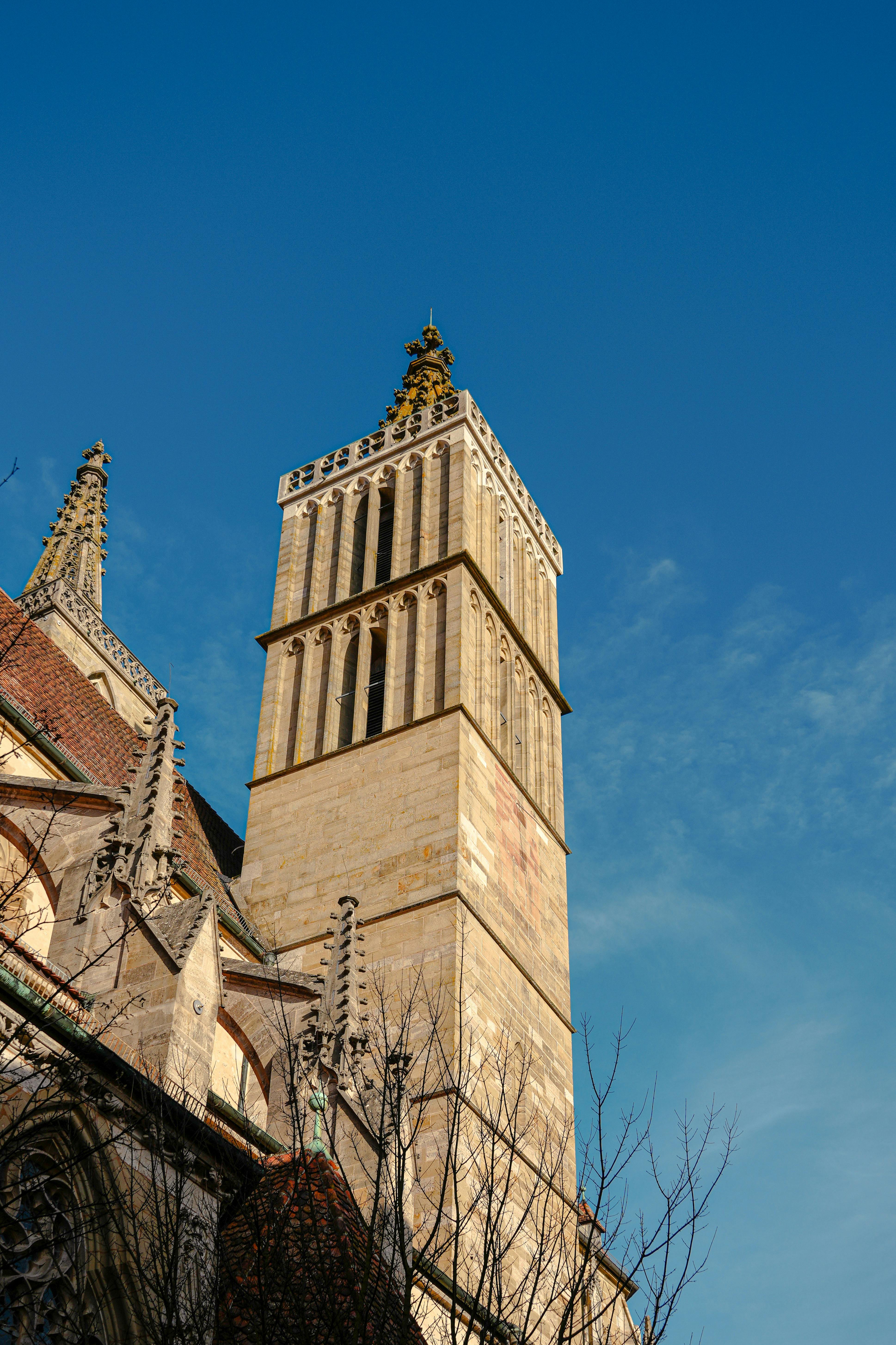 Gothic architecture of St. Jakob's Church against a clear blue sky in Rothenburg ob der Tauber.