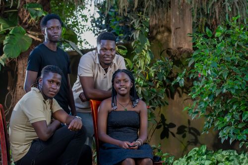 Free A group of four young adults enjoying a peaceful moment in a lush green garden. Stock Photo