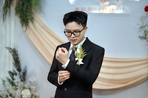 Free Groom in black suit adjusting cufflinks in elegant indoor wedding setup. Stock Photo