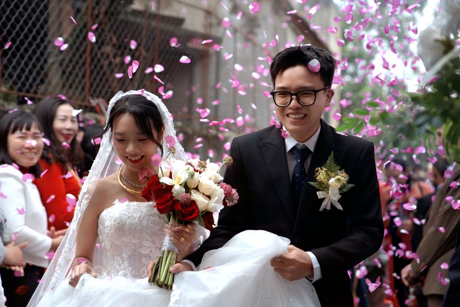 Happy couple celebrating their wedding amidst vibrant pink petals. Happy couple celebrating their wedding amidst vibrant pink petals.