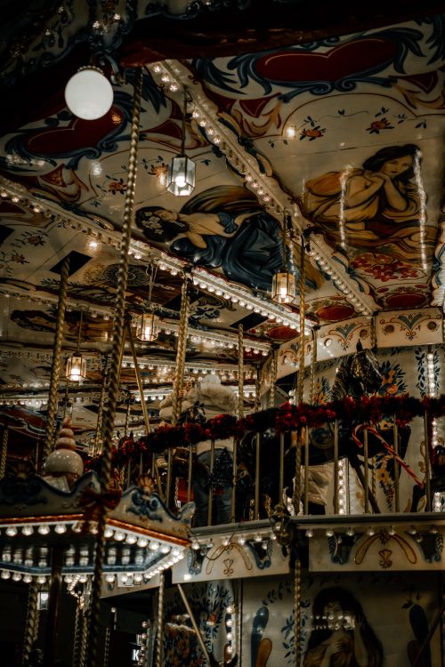 Free An intricately decorated vintage carousel featuring elaborate artistic details and warm ambient lighting. Stock Photo