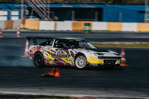 Free A dynamic shot of a race car drifting on a track, showcasing speed and precision. Stock Photo